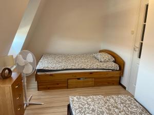 a small bedroom with a bed and a fan at Bursztynek in Hel