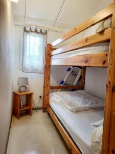 - une chambre avec 2 lits superposés et une table dans l'établissement Gîte VILLA 34 Résidence Le Grand Bleu, à Vendres
