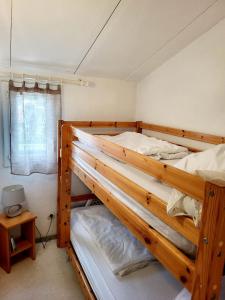 Ce dortoir comprend 2 lits superposés et une fenêtre. dans l'établissement Gîte VILLA 34 Résidence Le Grand Bleu, à Vendres