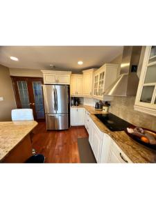 a kitchen with white cabinets and a stainless steel refrigerator at Hotel/Home in Windsor