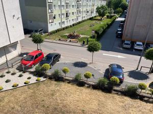 two cars parked in a parking lot next to a street at Bursztynek in Hel