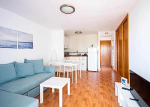 a living room with a blue couch and a kitchen at Apartamento Maypa 4 Arena in Meloneras