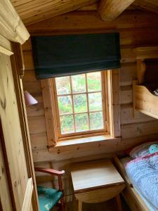 ein kleines Schlafzimmer mit einem Fenster in einem Blockhaus in der Unterkunft Timber Lodge in Uvdal Skisenter VIEW/WIFI in Sønstebø