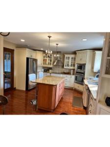 a kitchen with white cabinets and a island in it at Hotel/Home in Windsor