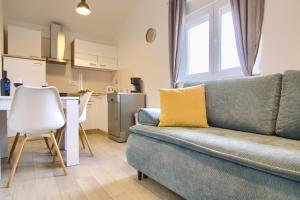 a living room with a couch and a kitchen at Piccolo Giardino in Kali