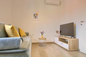 ein Wohnzimmer mit Sofa und Flachbildfernseher in der Unterkunft Piccolo Giardino in Kali