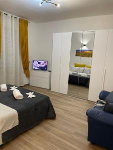 um quarto com uma cama, uma televisão e um sofá em Savonarola residence em Alessandria