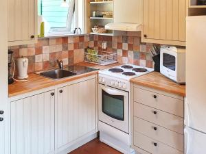 eine Küche mit einem weißen Herd Top-Backofen neben einer Spüle in der Unterkunft Holiday home in Ronneby in Ronneby