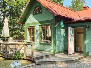 ein grünes Haus mit einer Veranda und einer Terrasse in der Unterkunft Holiday home in Ronneby in Ronneby