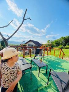 a young child wearing a hat standing next to a table at Cabana Ema in Curtea de Argeş