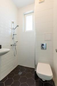 a white bathroom with a toilet and a sink at Villa Lеvandi in Sinemorets