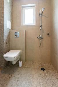 y baño con aseo y ducha. en Villa Lеvandi, en Sinemorets