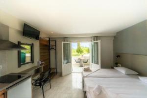 1 dormitorio con 2 camas y cocina con mesa en Nikos Villas en Kavos