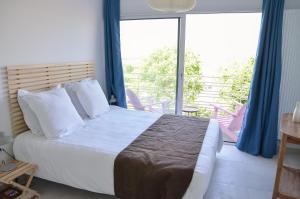 ein Schlafzimmer mit einem großen Bett und einem Balkon in der Unterkunft Le Toit Penché in Tardinghen