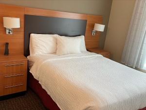 a bed in a hotel room with two night stands and two lamps at TownePlace Suites Orlando at FLAMINGO CROSSINGS® Town Center/Western Entrance in Orlando