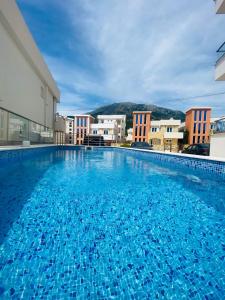 a large blue swimming pool with buildings in the background at Emma Lux Apartment in Dobra Voda