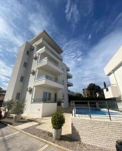 a white apartment building with a swimming pool at Emma Lux Apartment in Dobra Voda