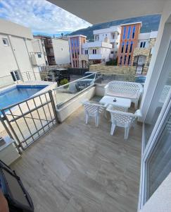 a balcony with a patio furniture and a pool at Emma Lux Apartment in Dobra Voda +6 photos