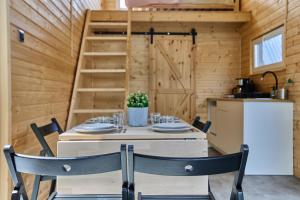 uma sala de jantar com mesa e cadeiras e uma cozinha em Domki RWL em Rewal