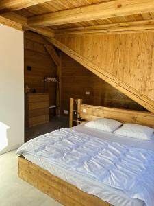 duże łóżko w pokoju z drewnianym sufitem w obiekcie Duplex La Tour w mieście Saint-Étienne-de-Tinée