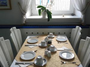 una mesa con platos y utensilios blancos. en Hotel Vila Bojana, en Bled