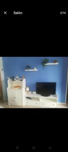 een wit bureau met een televisie en een blauwe muur bij Acogedora casa con piscina in Torrevieja