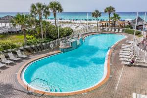 a swimming pool with chairs and the beach at The Resorts Of Pelican Beach 1413 Destin (Condo) in Destin