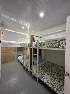 a dorm room with three bunk beds in it at Hostal Casa Jardin Cartagena in Cartagena de Indias