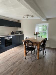 een keuken met een houten tafel en een aantal stoelen bij The Cottage in Exeter