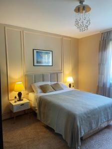 een slaapkamer met een groot bed en een kroonluchter bij M2 Suite by Central Park in Kragujevac