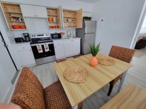 a kitchen with a wooden table with chairs and a kitchen with a stove at Sol Miami #1 with free parking on premises in Miami