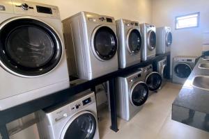 eine Reihe von Waschmaschinen und Trocknern in einer Waschküche in der Unterkunft Monoambiente al alcance de todo en Asunción-Luque in Luque