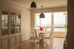 a dining room with a table and chairs and windows at Piso en Puerto de Altea in Altea