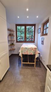 d'une salle à manger avec une table et une fenêtre. dans l'établissement Maison du quai à Saint Valéry sur Somme, à Saint-Valery-sur-Somme