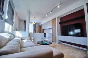 uma sala de estar com um sofá grande e uma televisão em Luxury 2 BR Penthouse - Pool - close to Paceville em St. Julian's