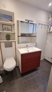 ein Badezimmer mit einem weißen Waschbecken und einer Toilette in der Unterkunft Maison du quai à Saint Valéry sur Somme in Saint-Valery-sur-Somme