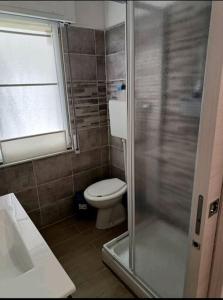 een badkamer met een toilet en een glazen douche bij b&b Poseidone in Alassio