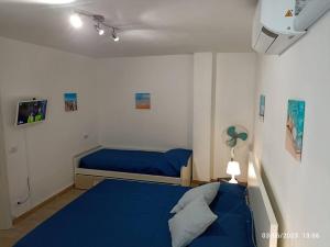 een slaapkamer met een blauw bed in een kamer bij b&b Poseidone in Alassio