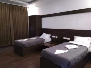 a hotel room with two beds with white towels on them at Belair Resorts in Kotagiri