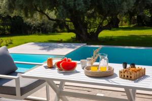 a picnic table with food on it next to a pool at Averto Villas with private pool in Nydri