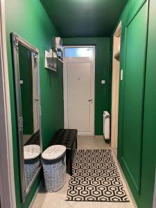 een groene kamer met een bank en een spiegel bij M2 Suite by Central Park in Kragujevac