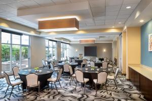 a conference room with tables and chairs and a projection screen at TownePlace Suites Orlando at FLAMINGO CROSSINGS® Town Center/Western Entrance in Orlando