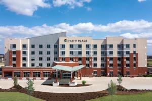 un grand bâtiment avec un panneau indiquant un emplacement rapide dans l'établissement Hyatt Place Fort Worth-Alliance Town Center, à Fort Worth