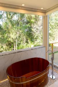baño con bañera grande y ventana en Jardim das Pipas en Garibaldi