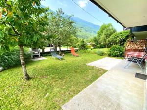 einen Garten mit Stühlen, einem Tisch und einem Baum in der Unterkunft Apartma EMI in Bovec