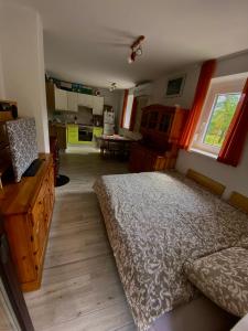 a bedroom with a large bed and a kitchen at Apartma EMI in Bovec