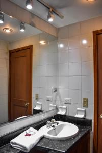 a bathroom with a sink and a large mirror at Cora 96 Street Apartments in Bogotá