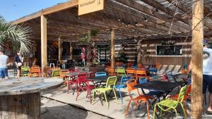eine Gruppe von Tischen und Stühlen auf einer Terrasse in der Unterkunft Mobil Home 4 personnes in Narbonne-Plage