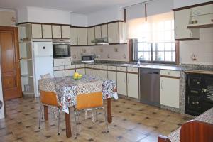 a kitchen with a table and a kitchen with white appliances at Os de Rey in Pontevedra