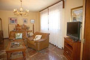 a living room with two chairs and a flat screen tv at Os de Rey in Pontevedra